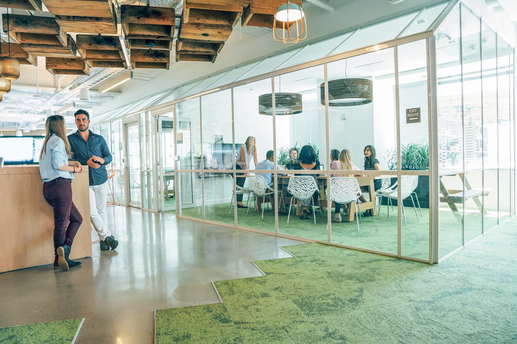 Web_Wide-Žmonių grupė, dalyvaujanti verslo susitikime modernioje biuro erdvėje